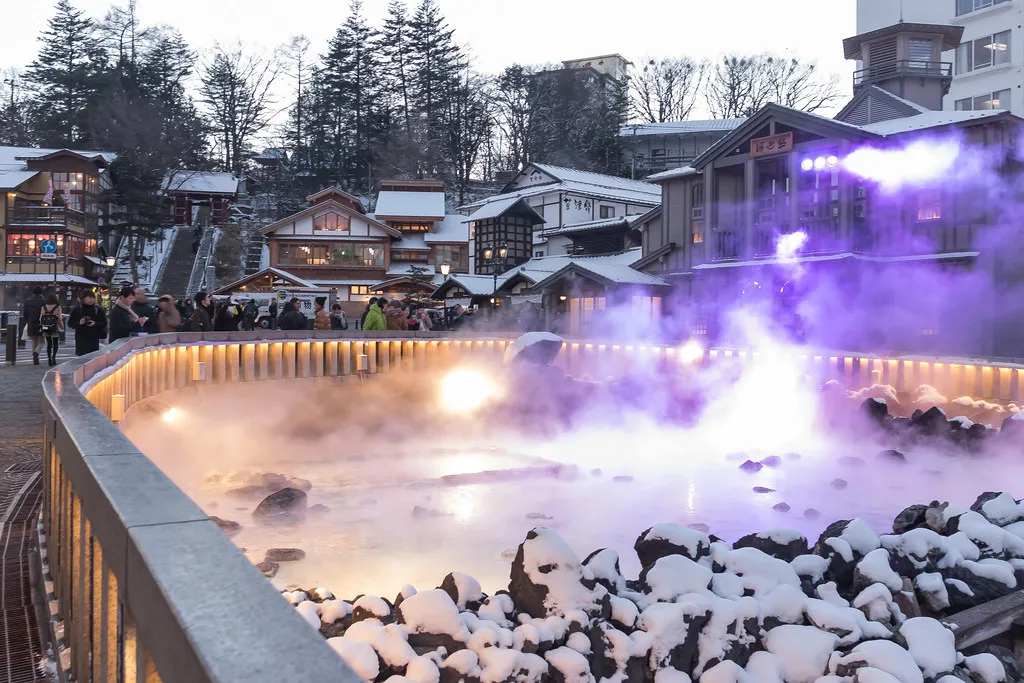Steam rising from a hot-spring source in a snowy onsen town